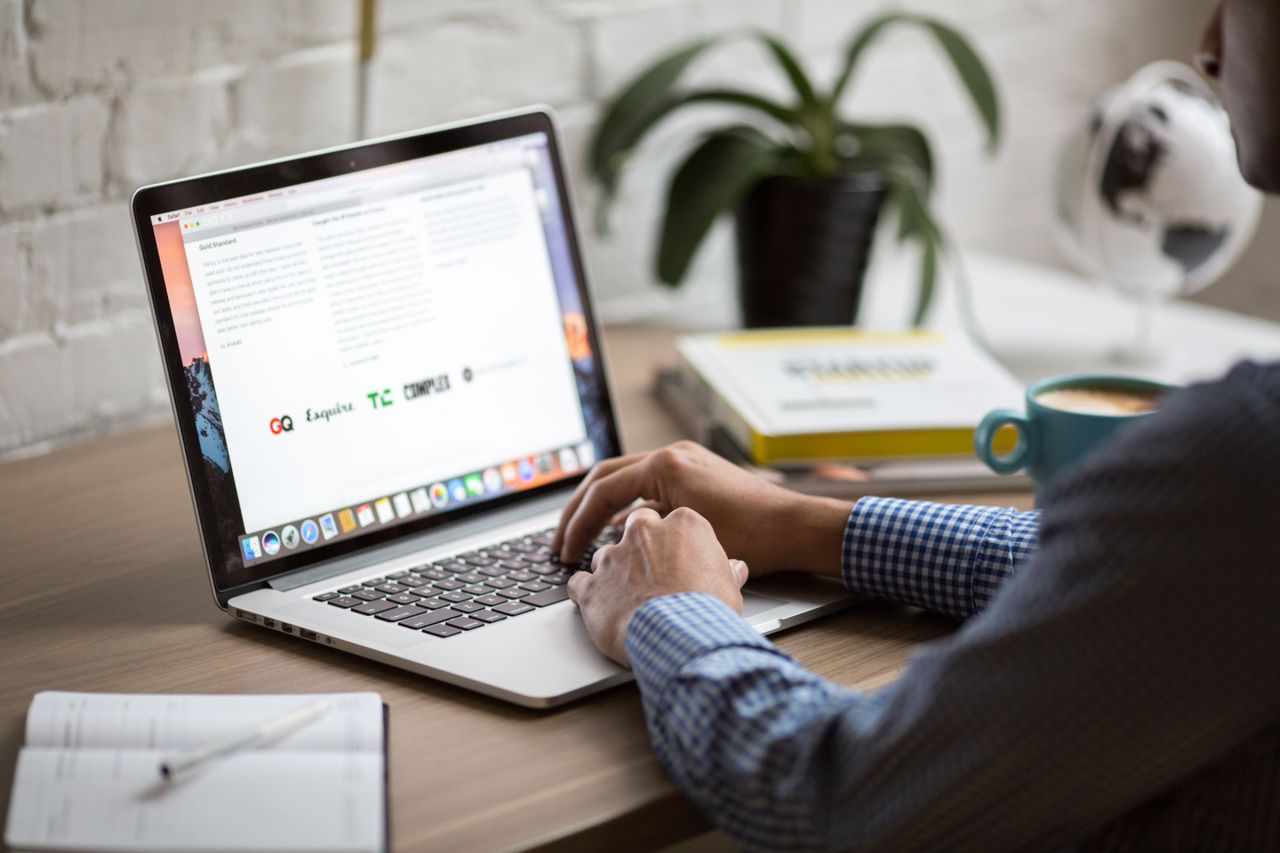 core-values A man working on a laptop at a desk with coffee, showcasing remote work in a modern office setting.